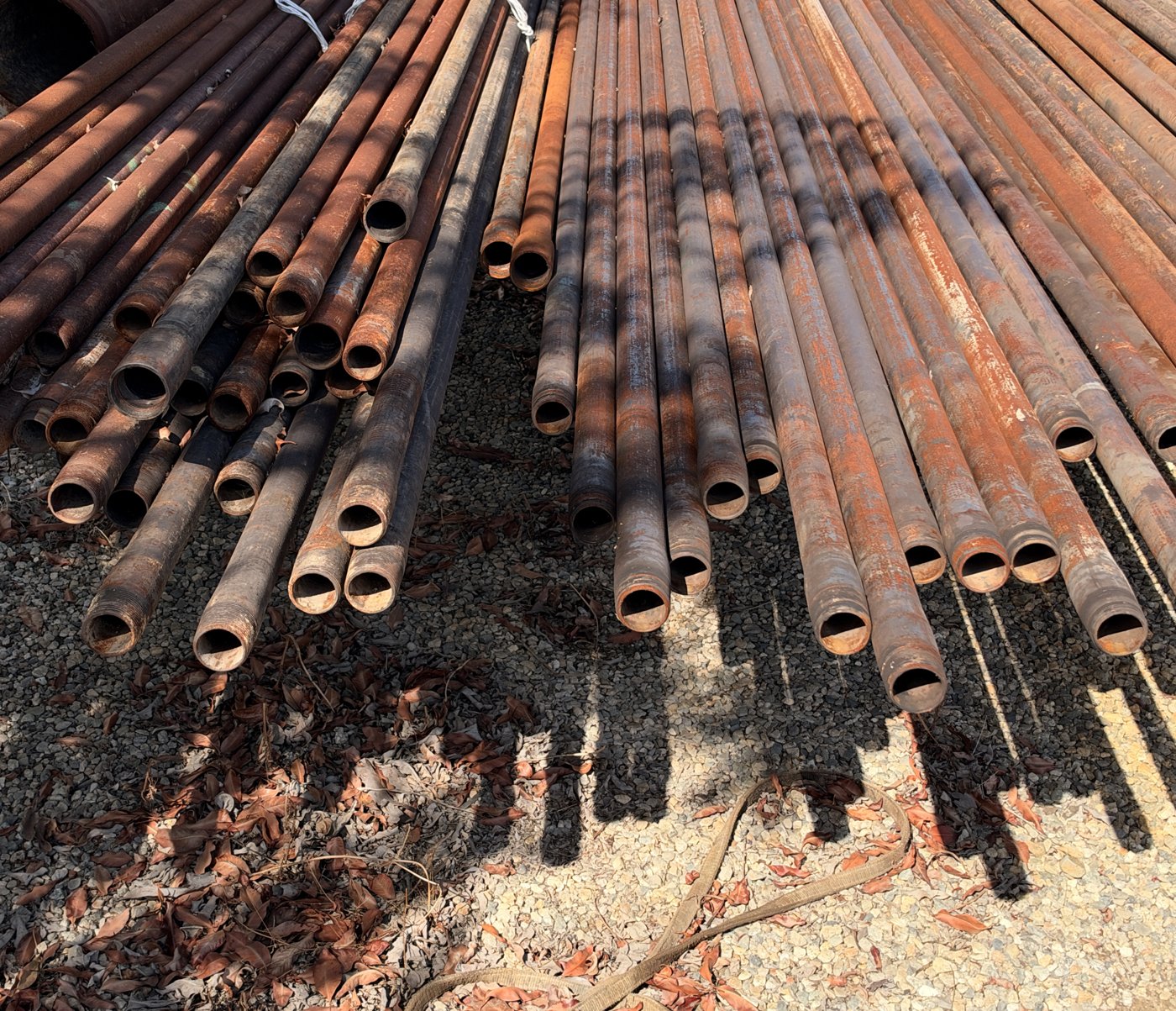 Used tubing joints stacked on gravel